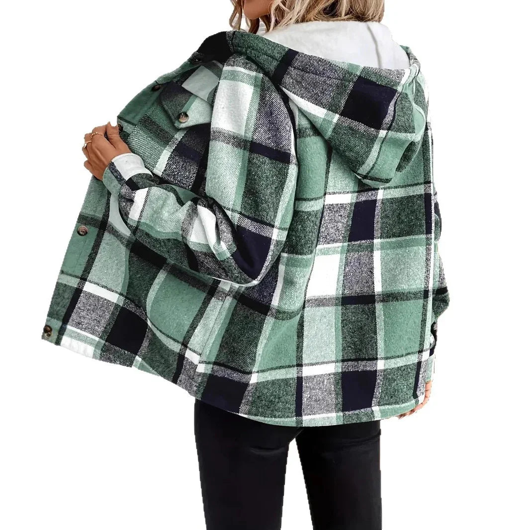 Woman wearing green and black plaid hooded jacket with white lining and black pants