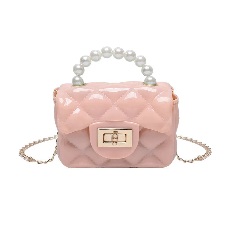 Small glossy pink quilted handbag with pearl handle and gold chain strap on white background