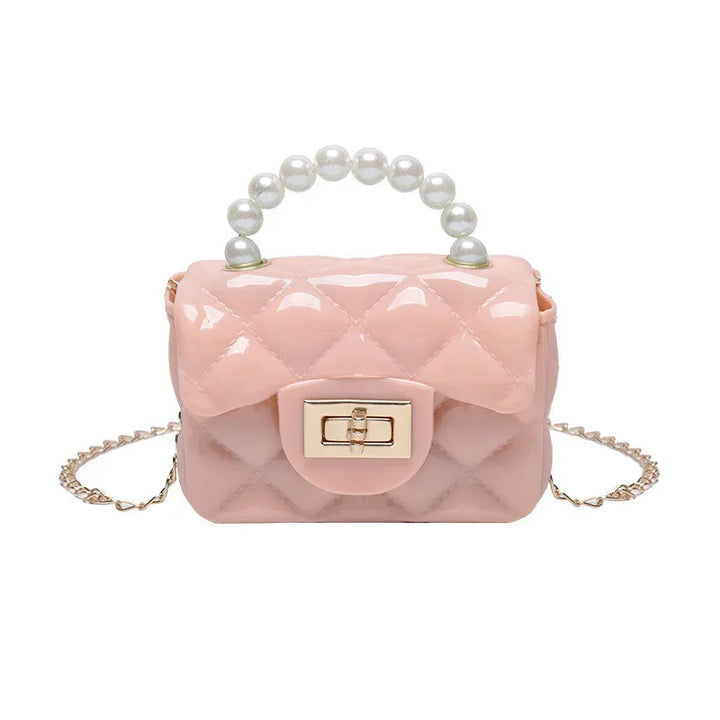 Small glossy pink quilted handbag with pearl handle and gold chain strap on white background