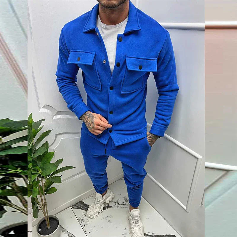 Man wearing a blue button-up jacket with flap pockets and matching blue jogger pants and white sneakers