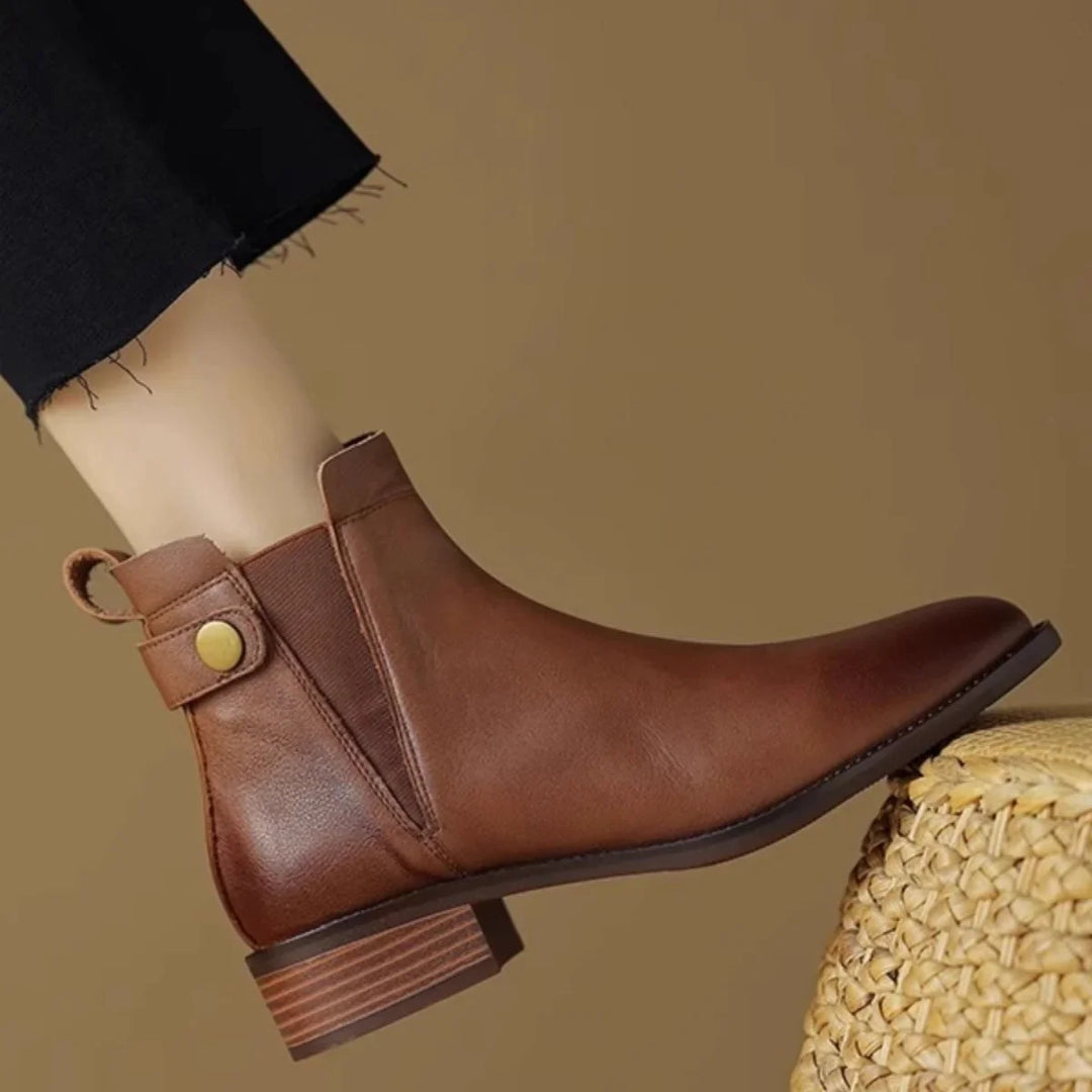 Brown leather ankle boot with side elastic panel and brass button on wooden heel