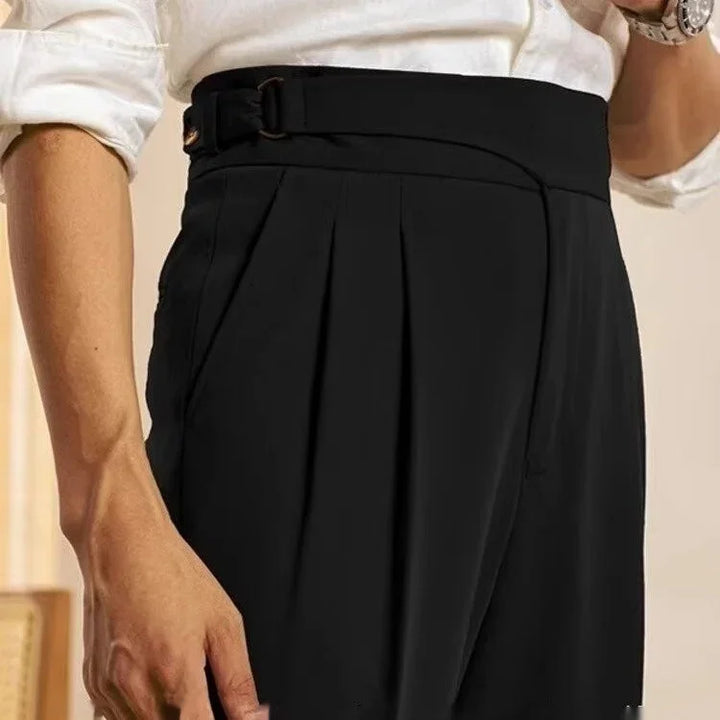 Close-up of man wearing black pleated trousers with side pockets and white rolled-up shirt