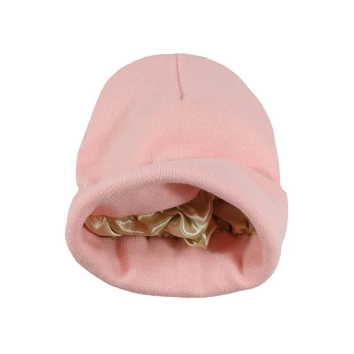 Light pink knitted beanie hat with beige satin lining inside