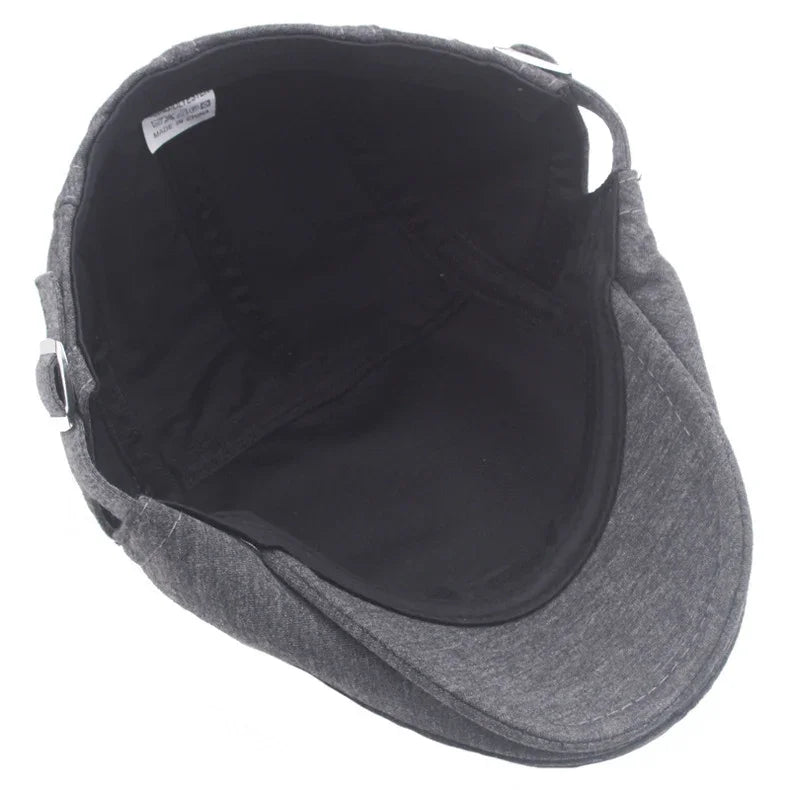 Grey fabric flat cap with black inner lining and adjustable metal buckle