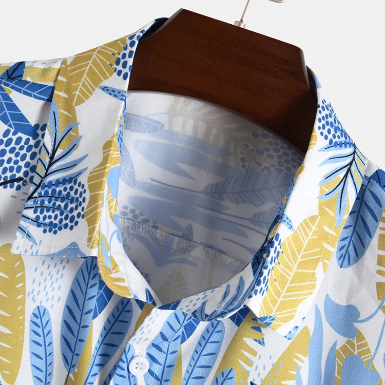 Close-up of tropical print shirt collar with blue and yellow leaf patterns on white fabric