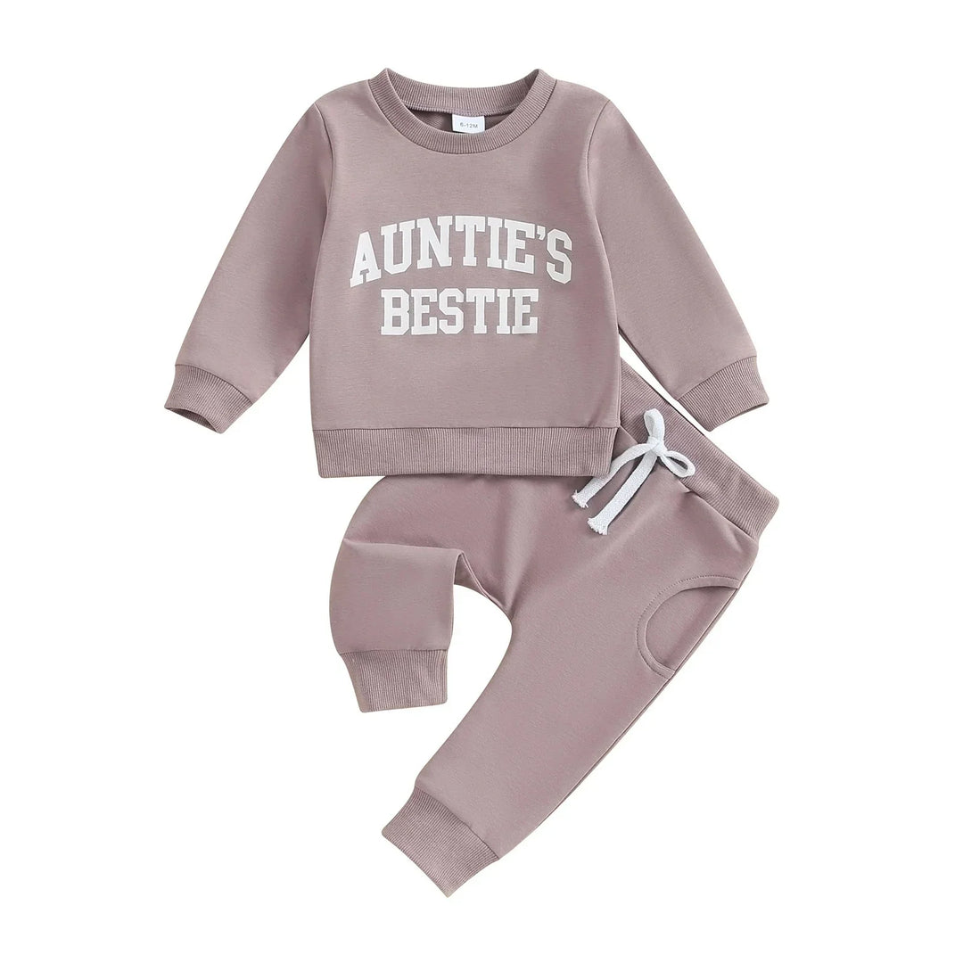 Mauve baby tracksuit with long sleeves and pants, white text reading 'Auntie's Bestie' on sweatshirt