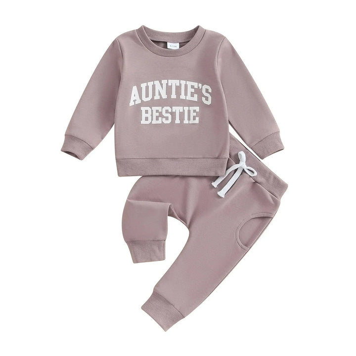 Mauve baby tracksuit with long sleeves and pants, white text reading 'Auntie's Bestie' on sweatshirt