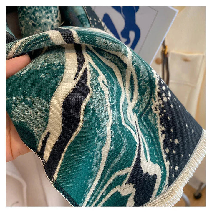 Close-up of hand holding green and black patterned fabric with white detailing and fringed edge