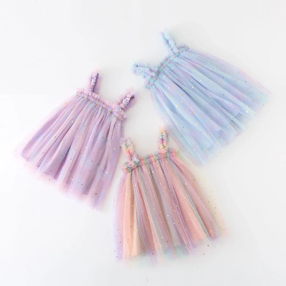 Three pastel tulle toddler dresses with star and moon glitter, in purple, blue, and pink shades