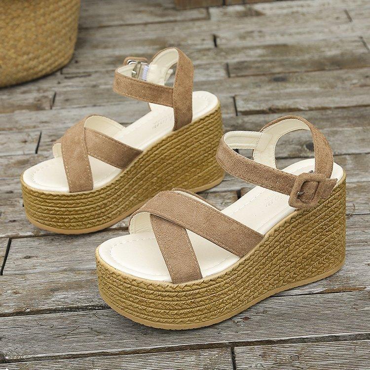 Beige suede platform wedge sandals with ankle strap and woven espadrille-style sole on wooden floor
