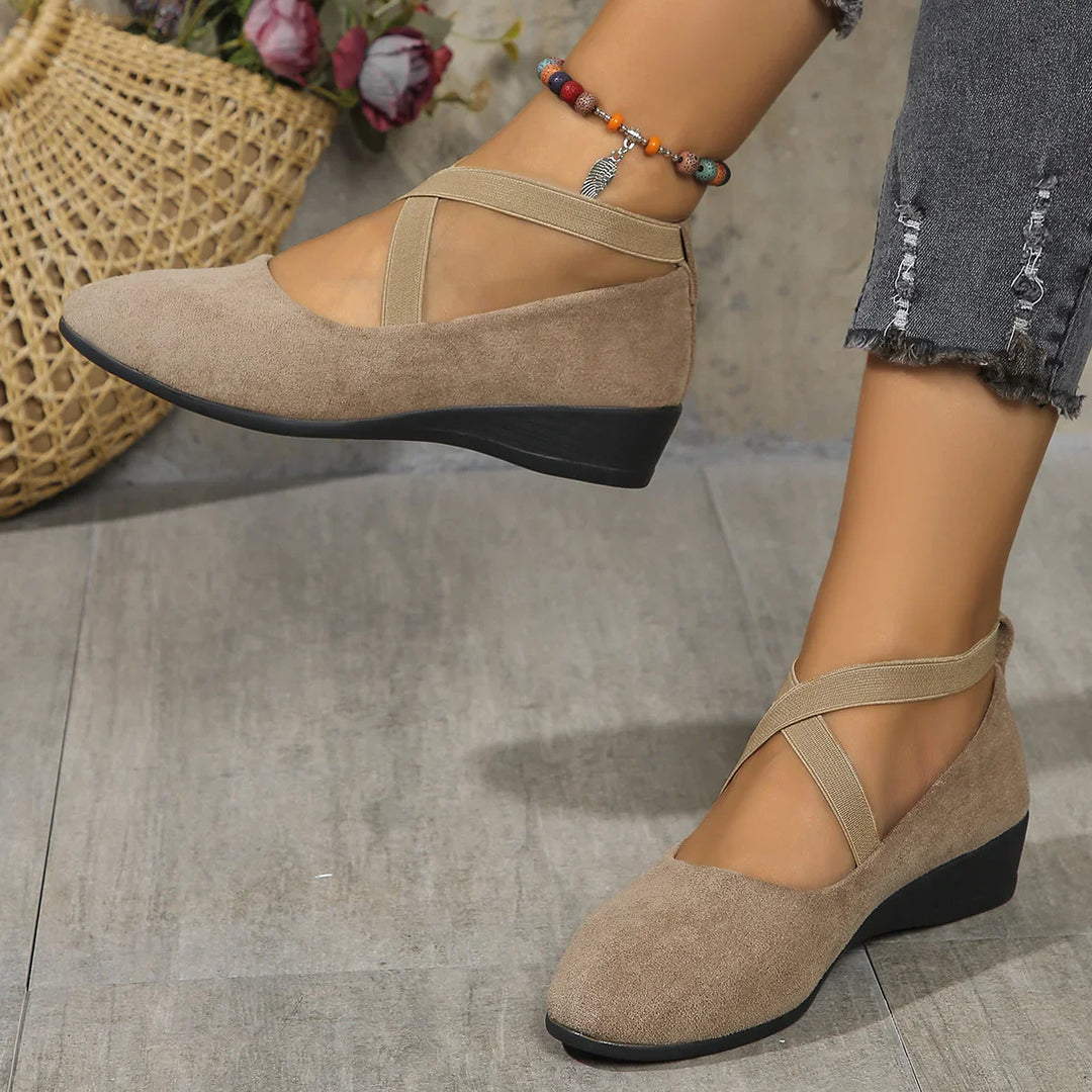 Beige suede wedge shoes with crisscross straps worn with cropped distressed gray jeans and colorful beaded anklet