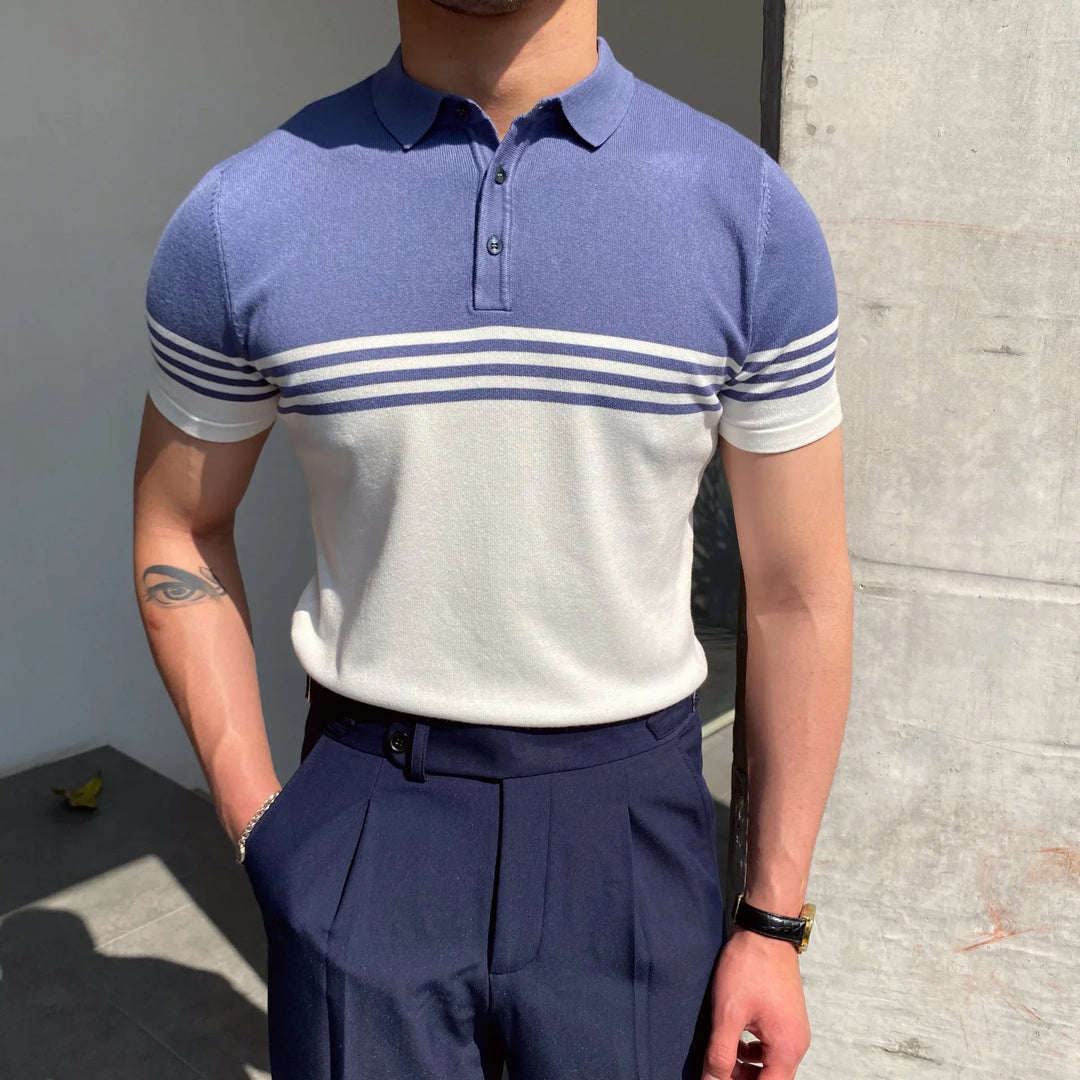 Man wearing blue and white striped short sleeve polo shirt with navy pleated trousers in natural light
