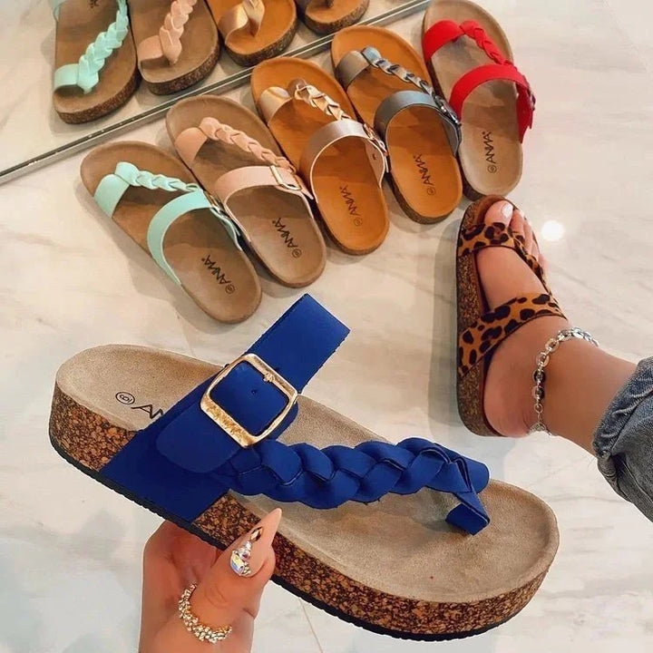 Collection of colorful braided strap cork sandals including blue, leopard print, red, gray, tan, pink, and mint green on marble floor