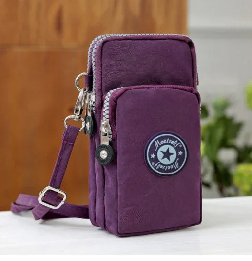 Purple canvas crossbody bag with dual zippered compartments and adjustable strap