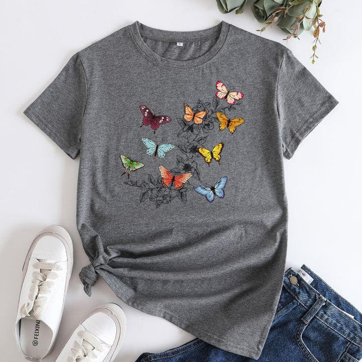 Gray t-shirt with colorful butterfly print paired with white sneakers and blue jeans on white background