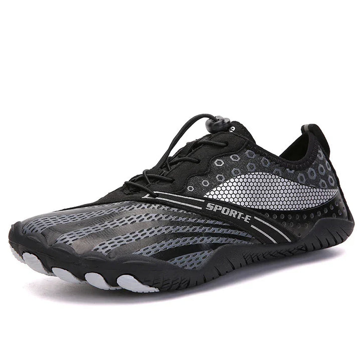 Black and gray sporty minimalist athletic shoe with hexagonal patterns and quick lace system