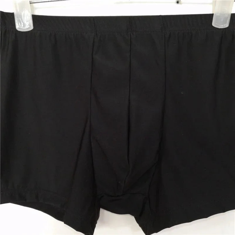 Black men's boxer briefs with elastic waistband hanging on clear hangers