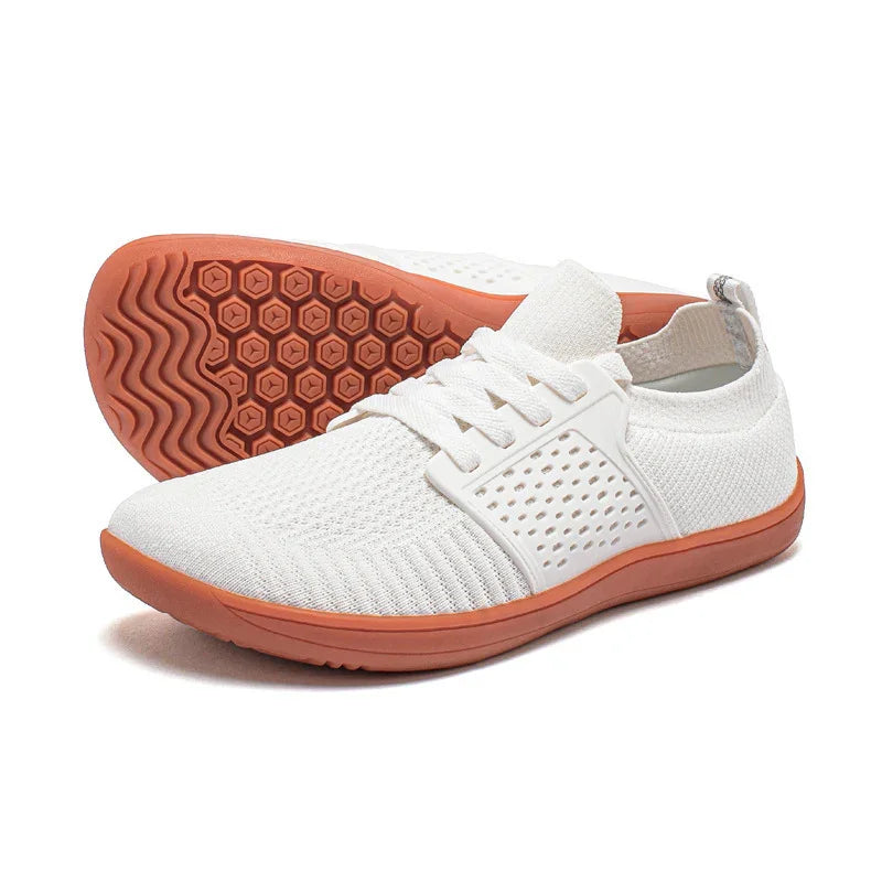 White lightweight breathable knit sneakers with brown rubber soles and hexagon pattern tread