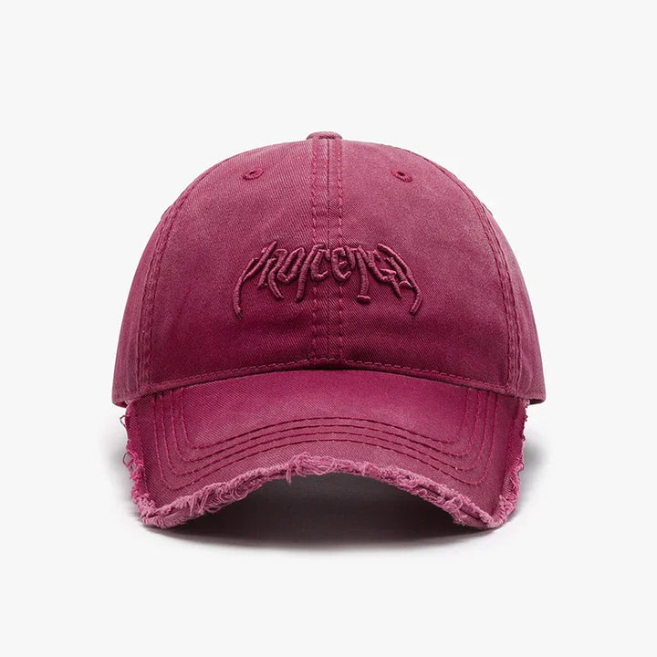 Front view of a vintage washed pink baseball cap with distressed edges and embroidered logo