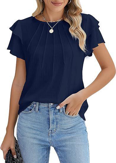 Woman wearing navy blue pleated short-sleeve blouse with ruffle detail, paired with light blue jeans