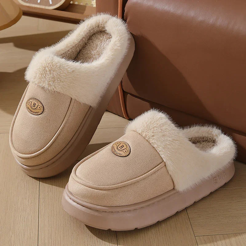 Beige cozy winter slippers with fluffy fur lining and soft EVA soles on wooden floor