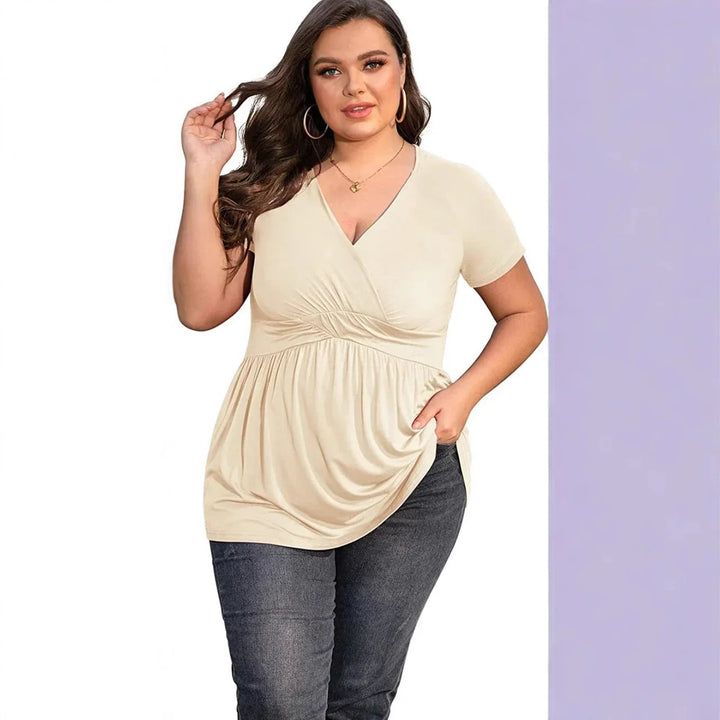 Plus size woman wearing beige short sleeve V-neck ruched top and dark jeans, casual outfit