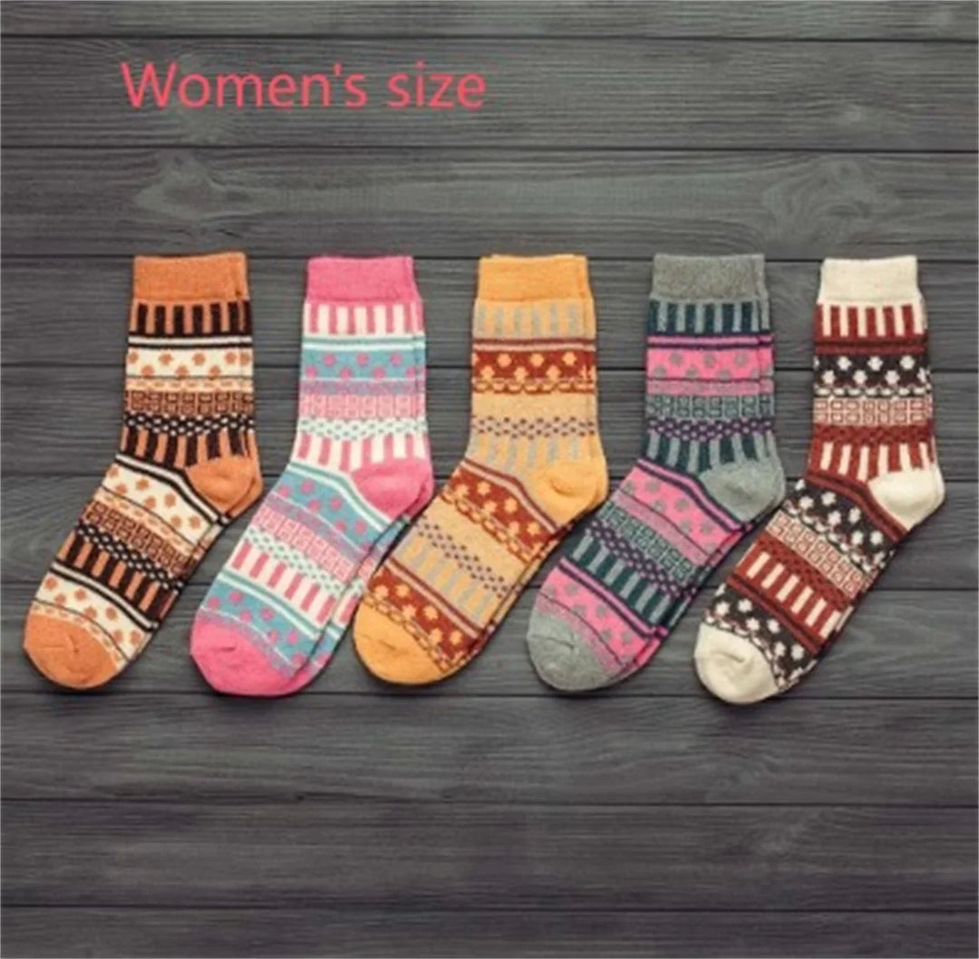 Five pairs of colorful women's patterned wool socks displayed on wooden background