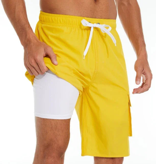 Man wearing bright yellow swim trunks with white inner compression shorts, showing layered design