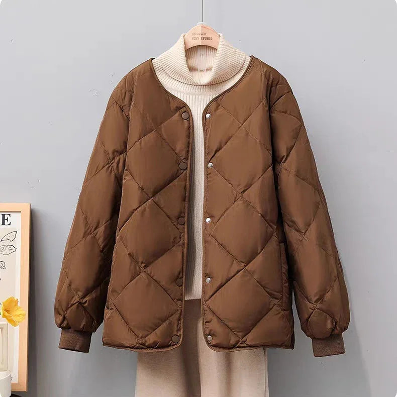 Brown quilted jacket with snap buttons layered over cream turtleneck sweater on hanger