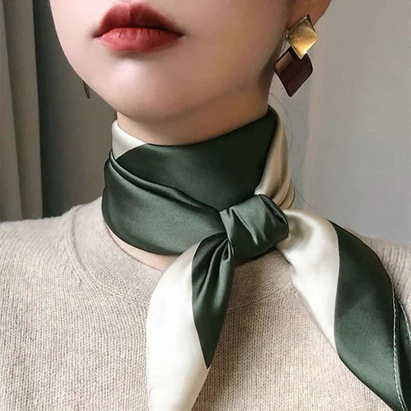 Close-up of woman wearing green and white silk neck scarf paired with geometric gold and brown earrings