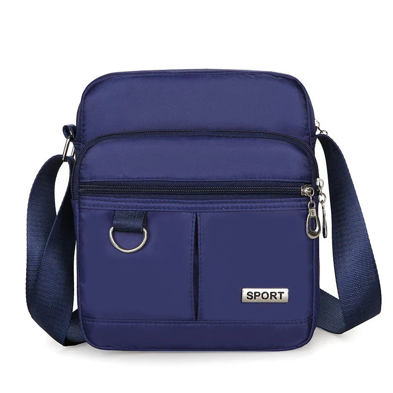 Navy blue crossbody sport bag with front zipper pockets and adjustable strap