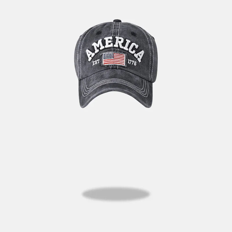 Gray baseball cap with white stitching, American flag patch, and 'AMERICA EST 1776' text