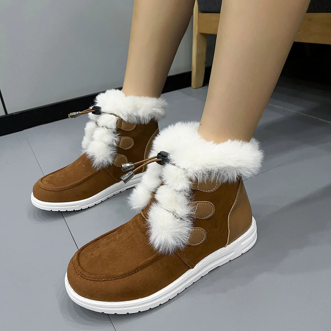 Brown winter boots with white fur trim and laces worn indoors on gray floor