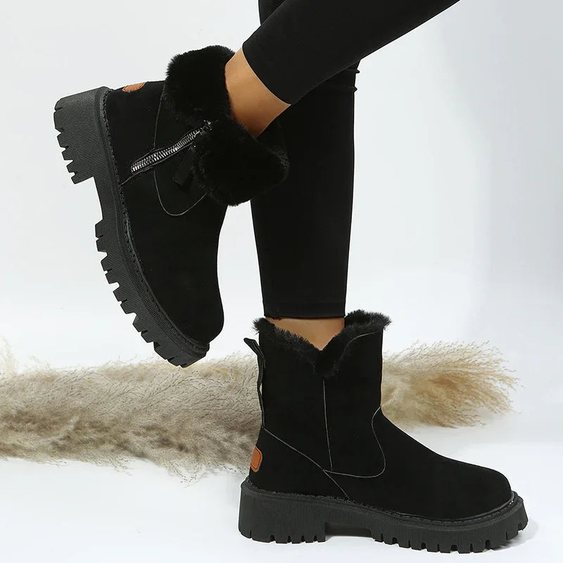 Black fur-lined winter ankle boots with chunky soles and side zipper worn with black leggings