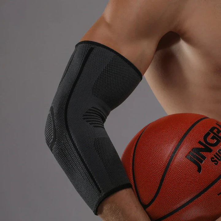 Basketball player wearing black elbow compression sleeve holding basketball