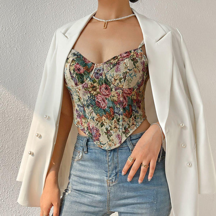 Woman wearing floral corset top, white blazer with pearl buttons, and light blue jeans