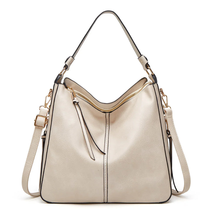 Cream leather shoulder bag with gold zipper, black trim, and adjustable strap