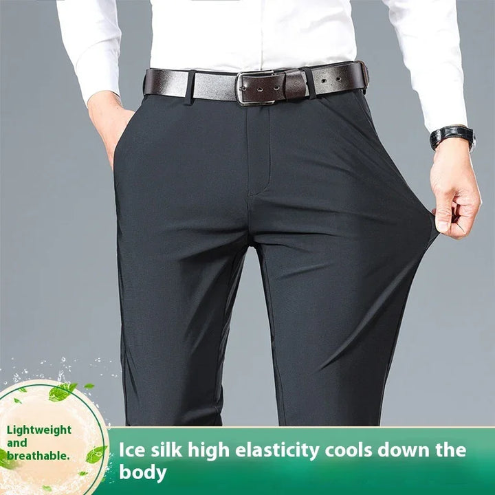 Man wearing black high elasticity ice silk pants with brown belt, stretching fabric to show flexibility