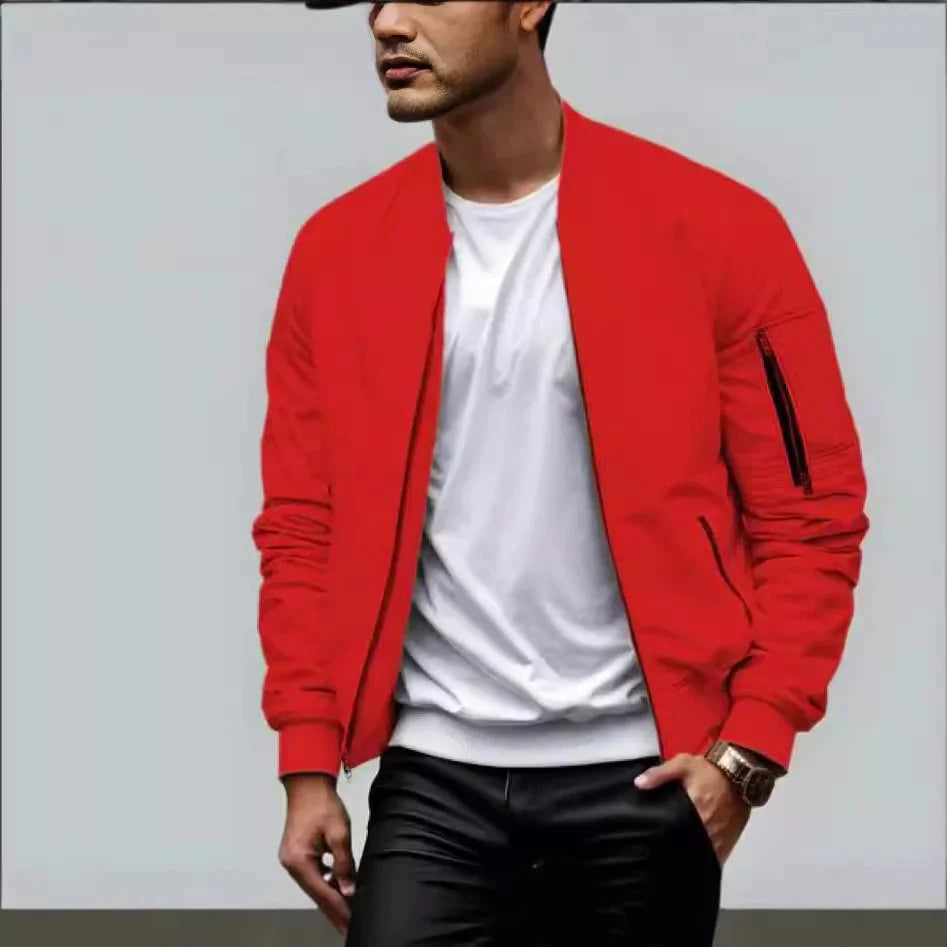 Man wearing red bomber jacket with white t-shirt and black pants against gray background