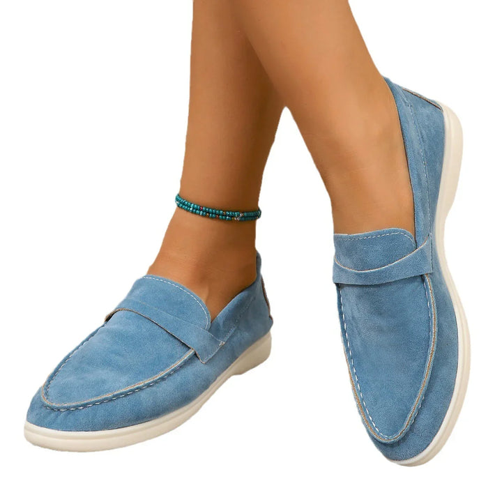 blue suede loafers with white soles worn with a beaded turquoise ankle bracelet on tanned legs