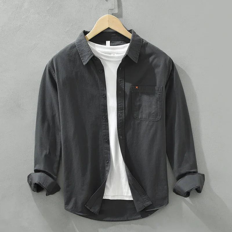 Black casual button-up shirt with chest pocket over white T-shirt on wooden hanger