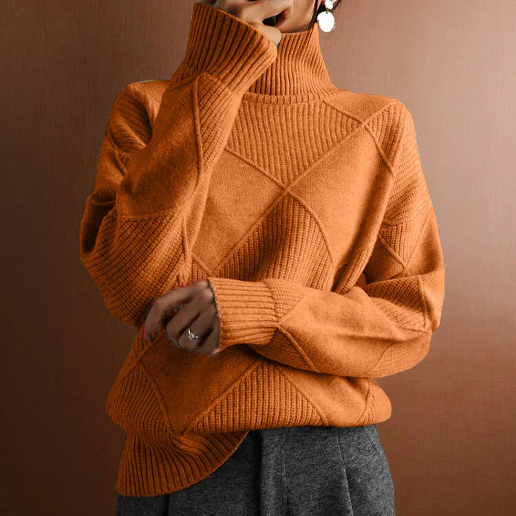Cozy orange turtleneck sweater with textured patterns worn by person with gray pants