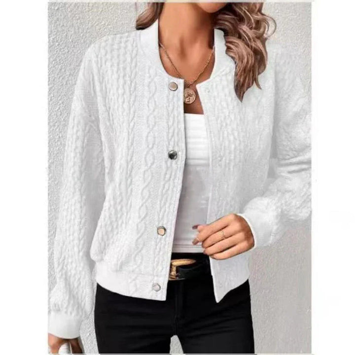 Woman wearing white cable knit button-up cardigan over white top with black pants and gold necklace