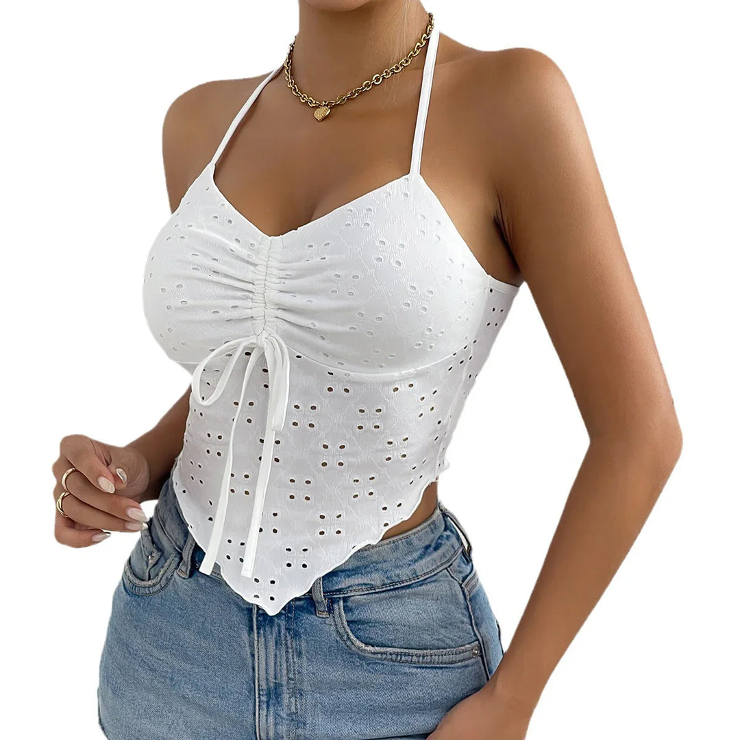 Woman wearing white eyelet lace halter crop top with ruched front and blue denim jeans