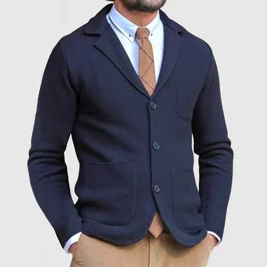 man wearing navy blue knit blazer with brown tie, white shirt, and khaki pants