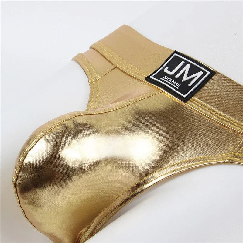 Shiny gold metallic men's thong underwear with JM JOCKMAIL logo waistband on white background