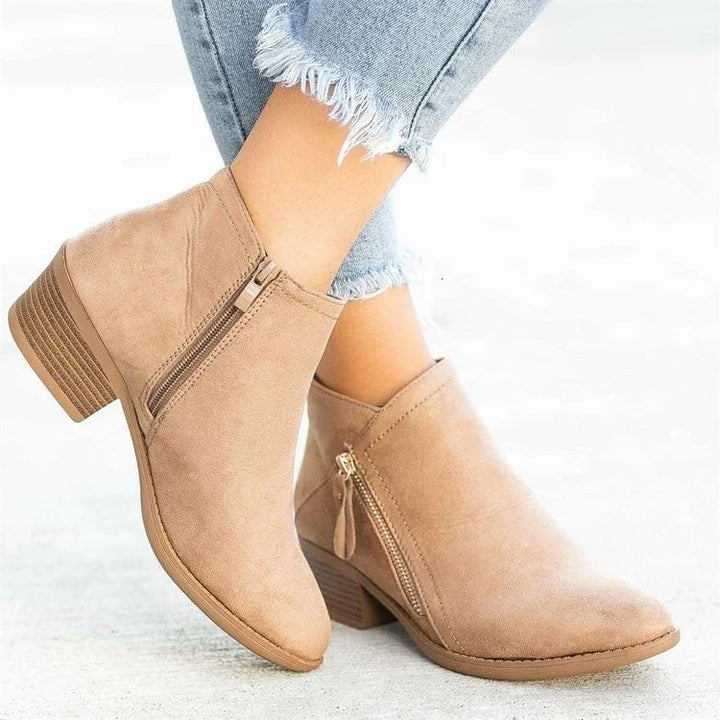 Tan suede ankle boots with side zippers worn with frayed hem light blue jeans