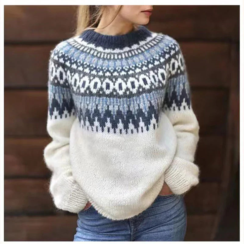 Woman wearing a cozy white and blue Nordic patterned knit sweater with long sleeves and jeans