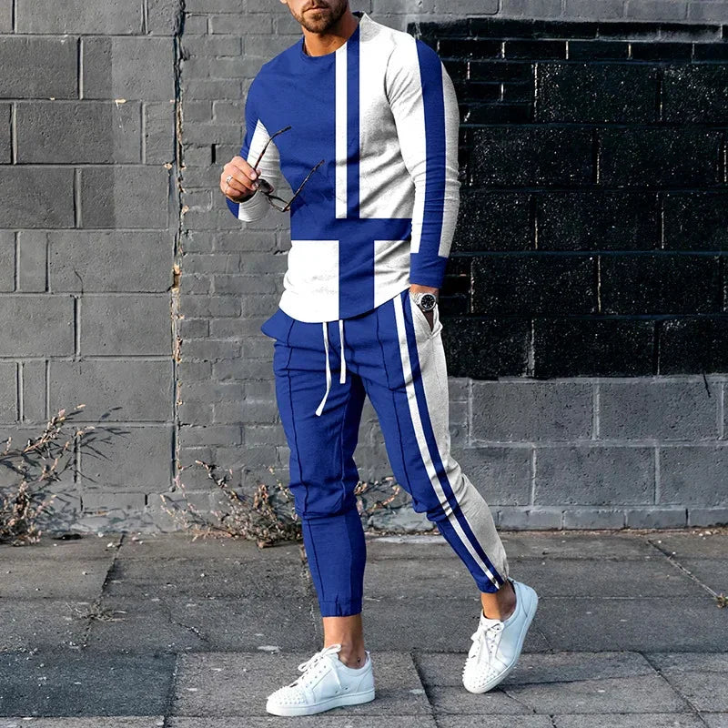 Man wearing blue and white colorblock tracksuit with white sneakers against gray brick wall