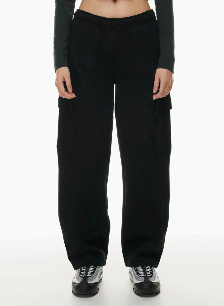 Woman wearing black cargo sweatpants and sneakers on white background